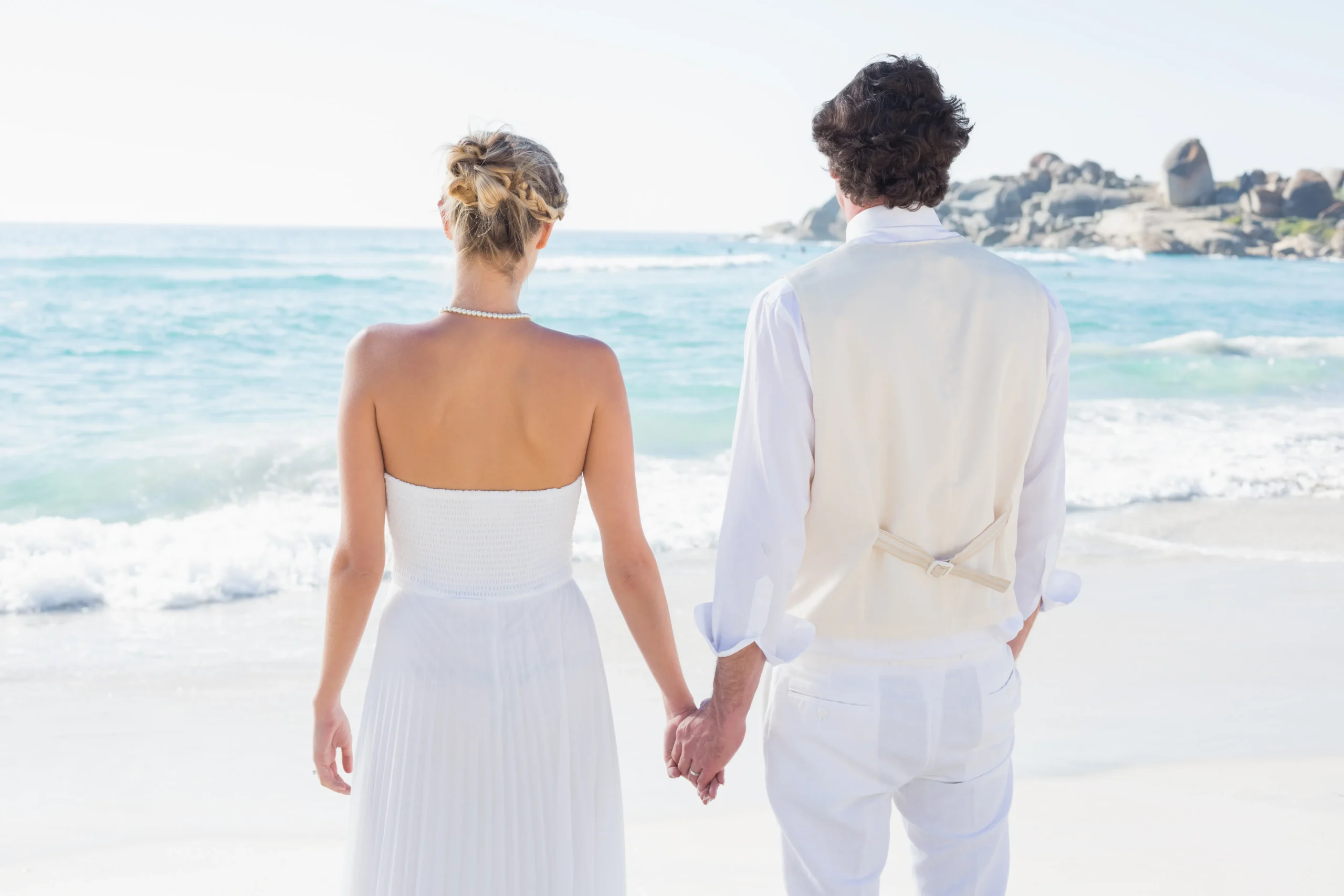 novia-y-el-novio-tomados-de-la-mano-mirando-al-mar_11zon