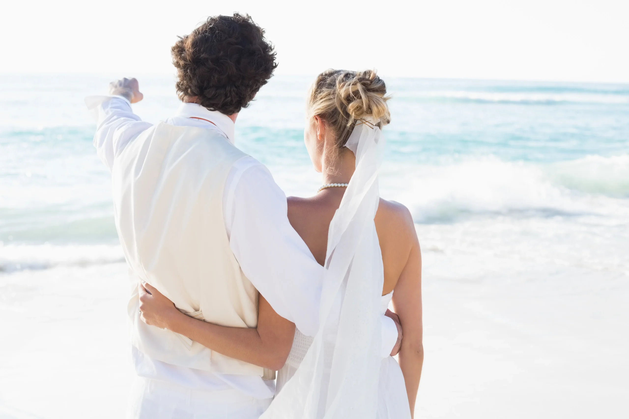 recien-casados-de-pie-junto-al-mar-con-marido-senalando_11zon