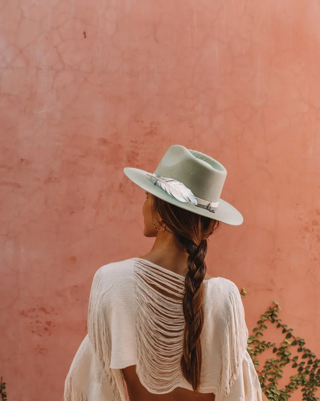 Guest in a wide-brimmed hat against a terracotta wall at TAGO Tulum